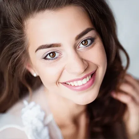 An attractive young woman smiling broadly and showing off her smile