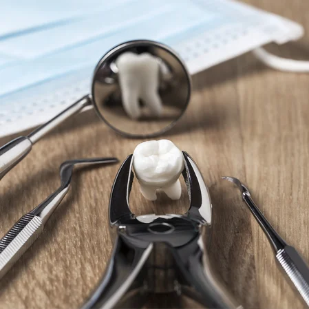 An extracted tooth amongst dental exam tools